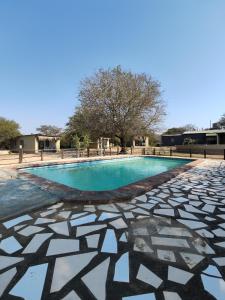 a swimming pool with a geometric design on the ground at Masango Lodge in Hoedspruit