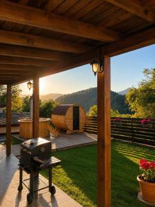 a grill on a patio with a view of a garden at Къща за гости Родопчани in Smolyan