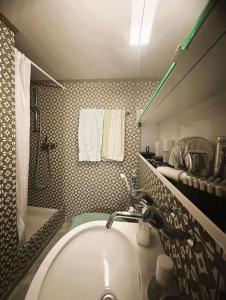 a bathroom with a tub and a sink and towels at Sam's Lakeview apartment in Ringgenberg