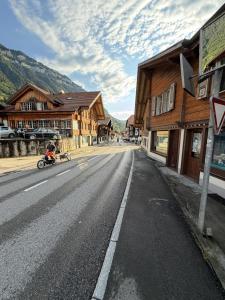 a person riding a bike down a street next to buildings at Sam's Lakeview apartment in Ringgenberg