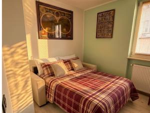 a bedroom with a bed with a plaid blanket at Casa di Paola Spormaggiore in Spormaggiore