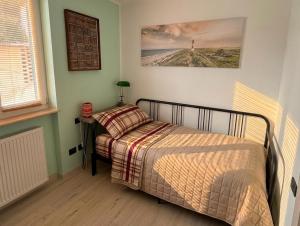 a small bedroom with a bed and a lamp at Casa di Paola Spormaggiore in Spormaggiore