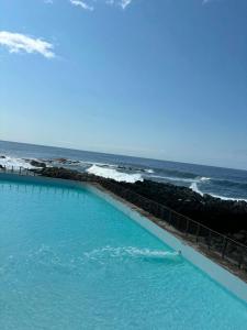 a swimming pool with the ocean in the background at Gite, Route Des Laves in Saint-Philippe