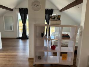 a white book shelf in a living room at Vilseck Stay - Studio Suite in Vilseck