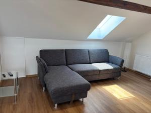 a couch and a chair in a living room at Vilseck Stay - Studio Suite in Vilseck
