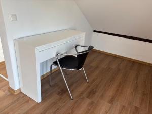 a black chair sitting next to a white desk at Vilseck Stay - Studio Suite in Vilseck