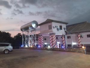 a building with a car parked in a parking lot at Zim Zam View Hotel in Onitsha