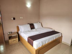 a bedroom with a bed with a wooden frame at Zim Zam View Hotel in Onitsha