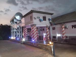 a small house with a water tower next to it at Zim Zam View Hotel in Onitsha +2 photos