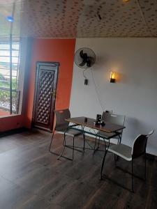 a room with a table and chairs and a door at Zim Zam View Hotel in Onitsha