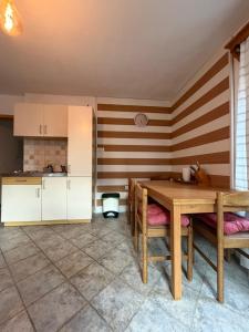 a kitchen with a wooden table and chairs in a room at Hiša Mila in Bovec +7 photos