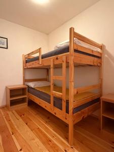 a bunk bed in a room with wooden floors at Hiša Mila in Bovec