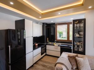 a kitchen with black and white appliances and a couch at Alfred Promenade Apartments in Sarandë