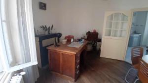 a room with a wooden desk and a door at Charming house in Montbron +5 photos