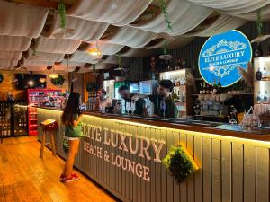a little girl standing in front of a bar at Garsoniere Victor Seaview Aer Conditionat- Bucatarie-Primim Carduri Vacanta-Pet Friendly la 3 minute de Plaja Reyna-Zoom Beach in Constanţa