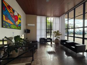 a living room with couches and a painting on the wall at Brisamar Suite Hotel in Florianópolis