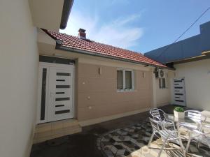 a patio with chairs and a building with a garage at Apartmani Strahinic in Leskovac
