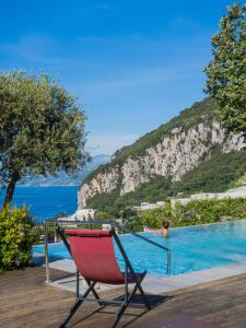a red chair sitting next to a swimming pool at Capri Wine Hotel in Capri