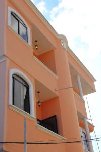 an orange building with windows on the side of it at Hostal Duncan in Puerto Ayora