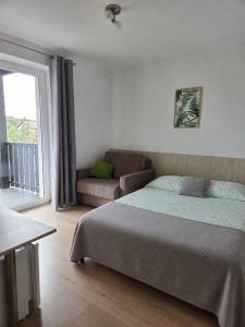 a bedroom with a bed and a couch and a window at Willa Plażowa in Mielno