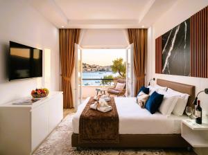 a hotel room with a bed and a large window at Alfred Promenade Apartments in Sarandë