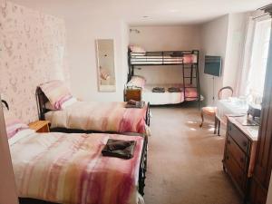 a bedroom with three bunk beds and a sink at Ardross Cottage in Aberfoyle