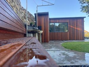 a wooden bench sitting in front of a house at Acouga in Miñortos