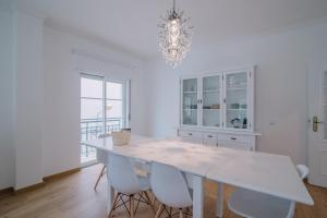 オリョンにあるCasa do Jardimの白いテーブルと椅子のある白いダイニングルーム