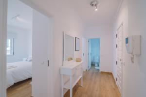 オリョンにあるCasa do Jardimの白いベッドと白い洗面台のある白い寝室