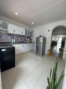 a kitchen with white cabinets and a black refrigerator at Guajira Sunset Hostal in Ríohacha