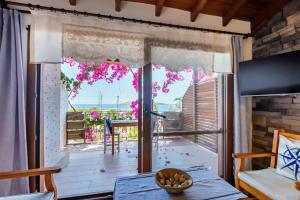 a room with a view of a balcony with pink flowers at Liman Pansiyon Palamutbükü in Datca