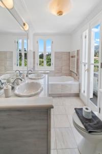 a white bathroom with two sinks and a tub at Villa Cypress with Private Pool and Mountain Views in Andros +17 photos