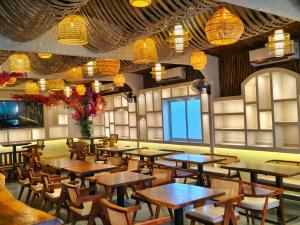 a restaurant with wooden tables and chairs and lights at Mohar Residency Madhyamgram in kolkata