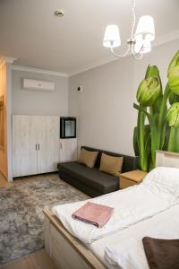 a living room with a bed and a couch at V8-Kelemen Panzió in Makó
