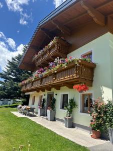 a building with a balcony with flowers on it at Oberhub am Kleinsonnberg in Taxenbach