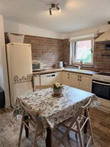 a kitchen with a table and a refrigerator at Ubytovanie Lišov 3 - Vidiecky dom in Lišov