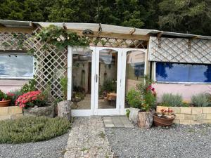 a front door of a house with flowers and plants at Akerama farm stay in Hukerenui