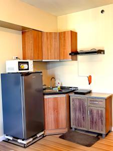 a kitchen with a refrigerator and a sink at New OneHeart Avida Riala T5 Condo in Cebu City