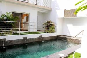 a swimming pool in front of a house at Hôtel Baie des Anges in Gustavia