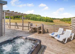 a deck with a hot tub and two chairs and a table at Henfields Country Retreat in Cannington +145 photos