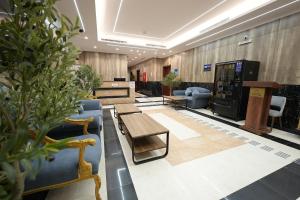 a lobby with couches and tables and potted plants at فندق النخبة البلاتيني - Platinum Elite Hotel in Medina