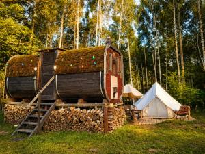 a small house with a tent and a white at Glempings Pasaka un pirts I tent and sauna in Vecumnieki