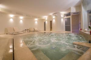 a swimming pool in a room with chairs and a table at Masseria Mongiò dell'Elefante in Otranto