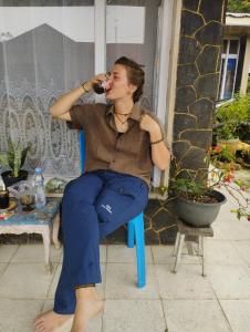 a woman sitting in a chair drinking a glass of wine at Hasbi Homestay Syariah in Bukittinggi