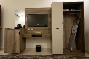 a living room with a tv and a entertainment center with a tv stand at فندق النخبة البلاتيني - Platinum Elite Hotel in Medina