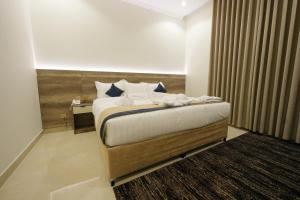 a hotel room with a bed and a night stand at فندق النخبة البلاتيني - Platinum Elite Hotel in Medina +101 photos