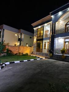 an empty parking lot in front of a house at night at Royce's Apartment in Kigali