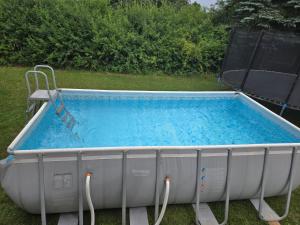 a large pool sitting in the grass with a chair at Apartament 1 w Leśnym Zaciszu in Czertyń