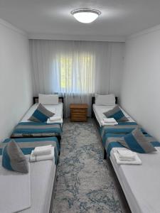 a room with three beds in a room at River guest house in Osh