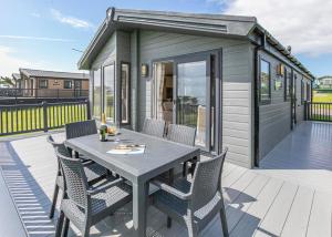 a tiny house with a table and chairs on a deck at Cherry Tree in Belton